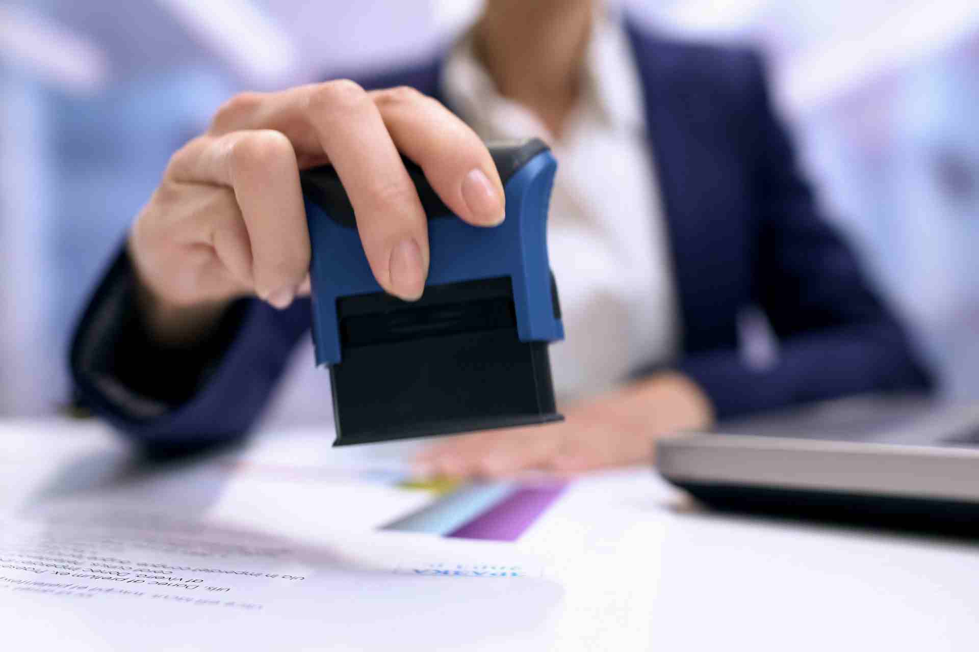 Notariusz przybija pieczątkę na umowie